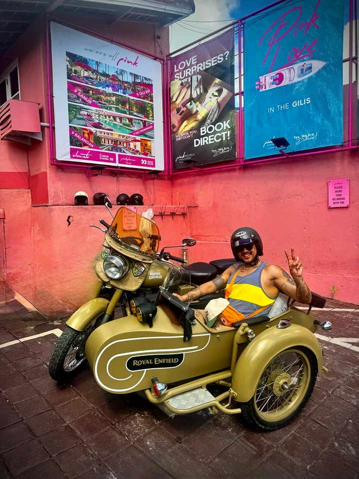 Guest enjoying a Royal Enfield sidecar beside a colourful local wall