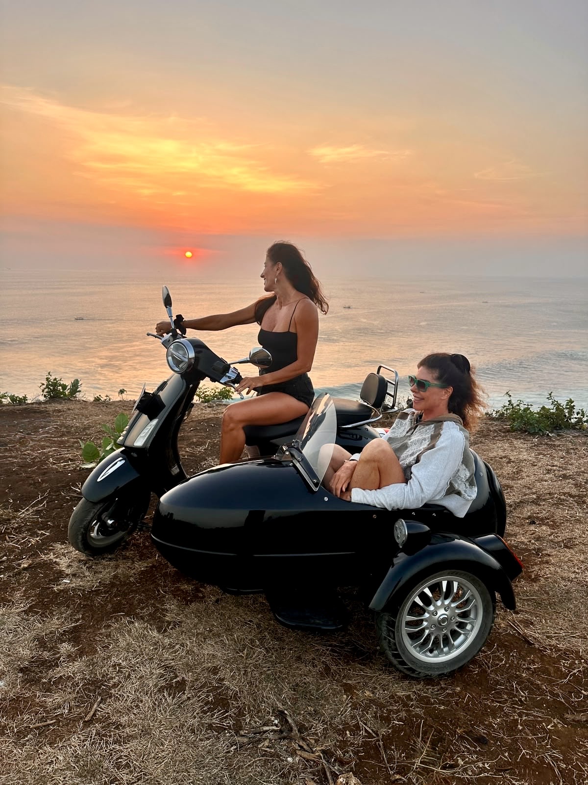 Guests enjoying a sidecar at sunset above the ocean