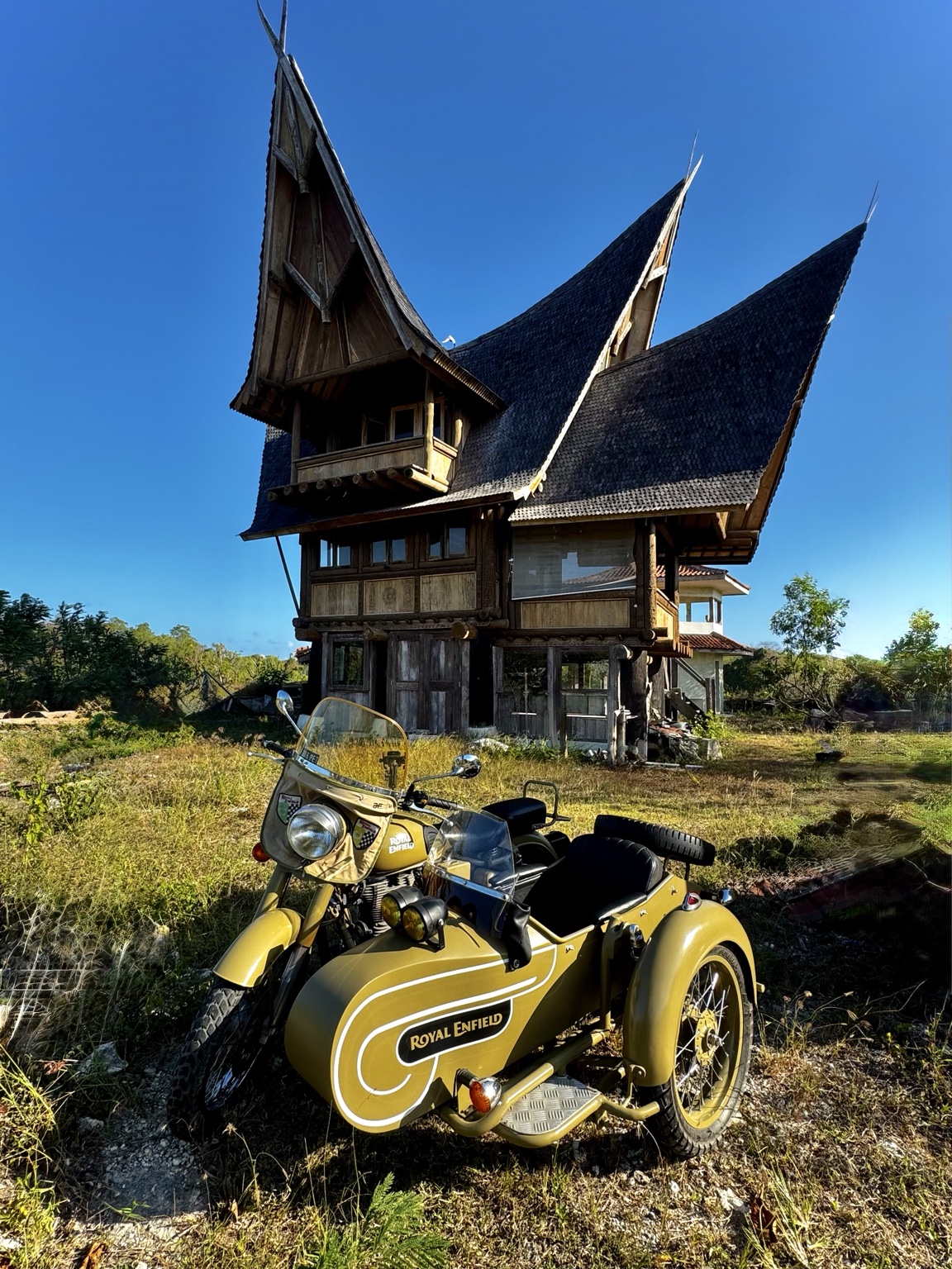 Royal Enfield sidecar beside distinctive architecture in Bali